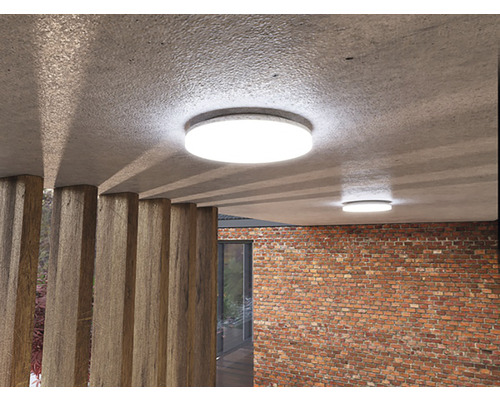 Dve okrúhle stropné svietidlá v miestnosti s tehlovou stenou a drevenými vzperami