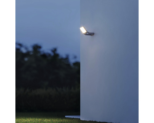 LED vonkajší reflektor namontovaný na stenu so svetelným kužeľom v záhrade