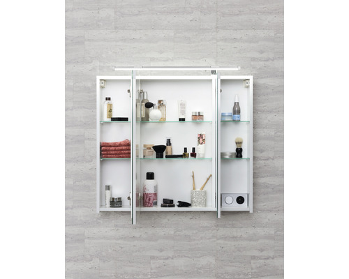 Otvorená zrkadlová skrinka so sklenenými policami a rôznymi kúpeľňovými potrebami