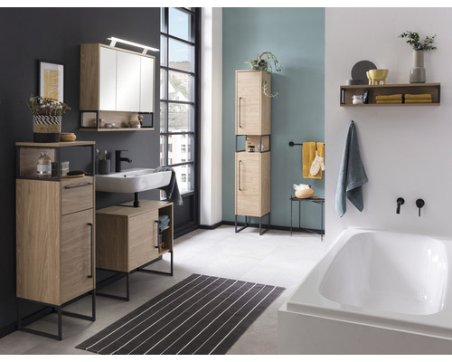 Moderná kúpeľňa s umývadlom, zrkadlovou skrinkou, vysokou skrinkou a vaňou vo svetlom drevenom dekore a čiernymi akcentmi.