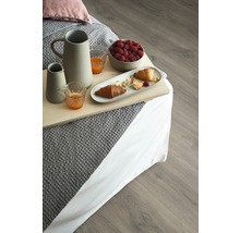 Snímka raňajok v posteli s nápojmi, croissantmi a malinami na drevenej podlahe