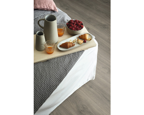 Snímka raňajok v posteli s nápojmi, croissantmi a malinami na drevenej podlahe