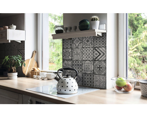 Kuchynská scéna s pracovnou doskou, drezom, čajovou kanvicou a obkladačkami v dizajne patchwork.