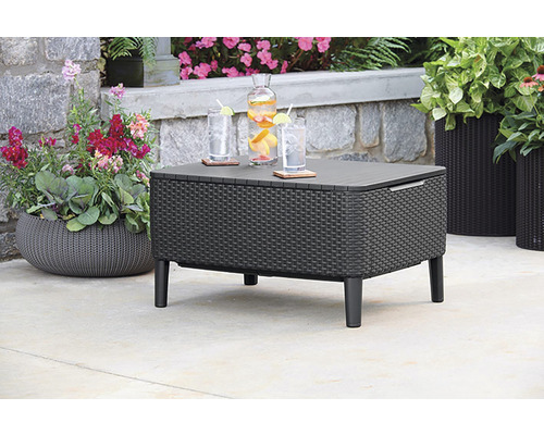 Záhradná scéna s chladiacim stolom z ratanu, nápojmi a kvetináčmi.