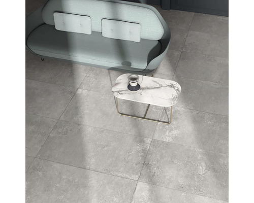 Sivé podlahové dlaždice v obývacej izbe s pohovkou a stolom