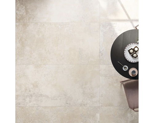 Svetlá podlaha s obdĺžnikovými dlaždicami vedľa stola s jedlom.