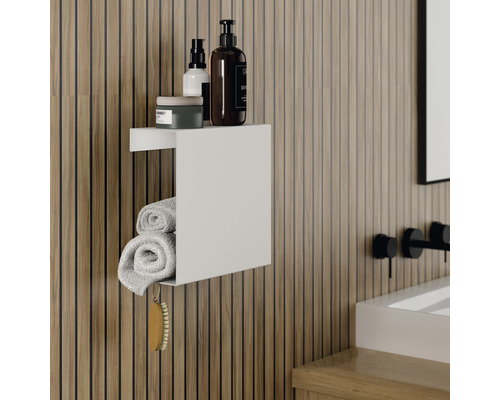 Kúpeľňa so svetlou drevenou stenou, biela nástenná polica s uterákmi a kozmetikou.