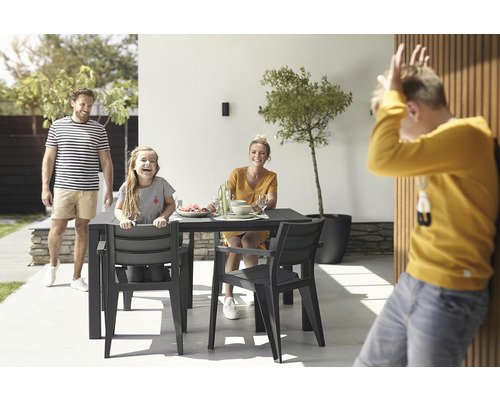 Rodina sedí vonku pri záhradnom stole so stoličkami