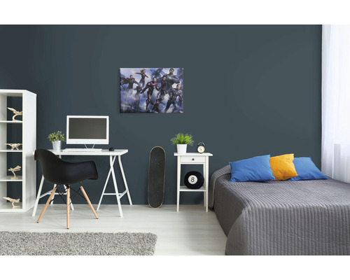 Zdobená izba s nástennou maľbou Avengers, stolom a posteľou