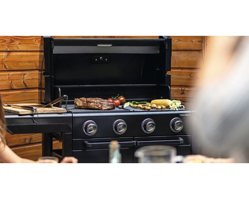 Plynový gril so steakom, zeleninou a kukuričnými klasmi na grilovacej mriežke