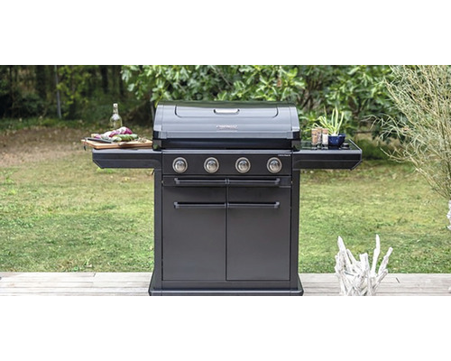 Tmavý plynový gril so štyrmi horákmi vonku s policami