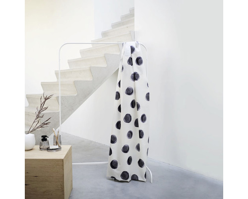 Záclona s bodkovaným vzorom na vešiaku na oblečenie vedľa schodiska