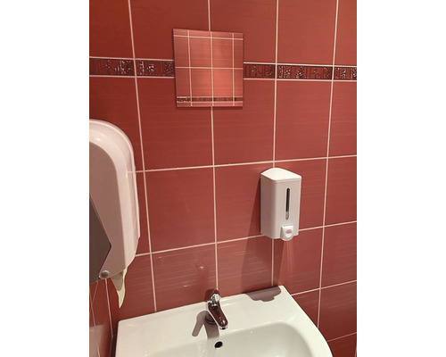 Kúpeľňové umývadlo s dávkovačom mydla a zrkadlom pred obloženou stenou