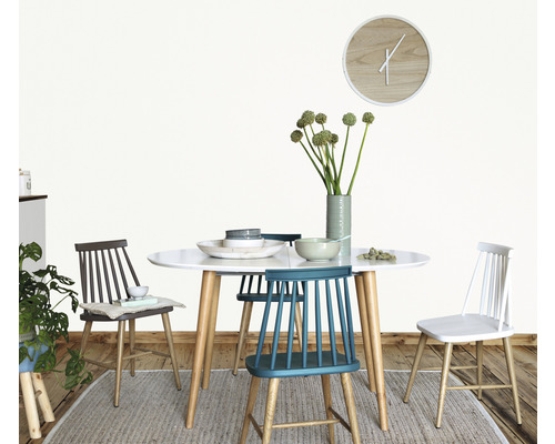 Jedálenský stôl so stoličkami, riadom a vázou s kvetmi vo svetlej miestnosti