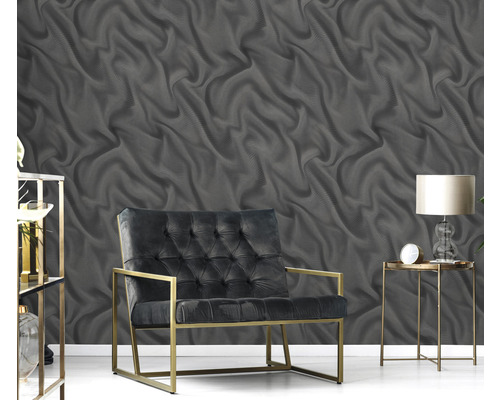 Izba so sivou tapetou s vlnitým vzorom, kreslom a stolom