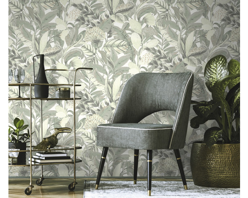 Scéna s kvetinovou tapetou, kreslom a barovým vozíkom.