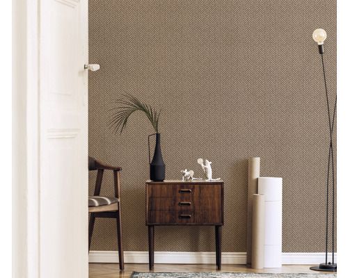 Obývacia izba so vzorovanou tapetou, komodou, stoličkou, stojacou lampou a dekoráciami.