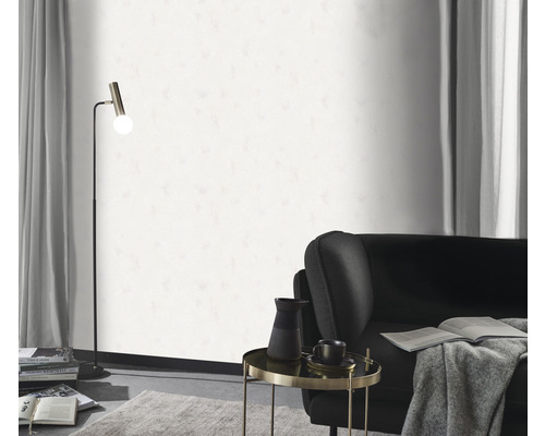 Obývacia izba so stojacou lampou, kreslom, príručným stolíkom a bielou tapetou