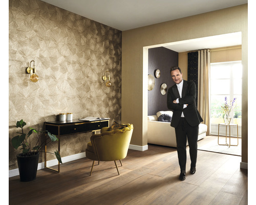 Obývacia izba s tapetou so vzorom, písacím stolom, kreslom a osobou