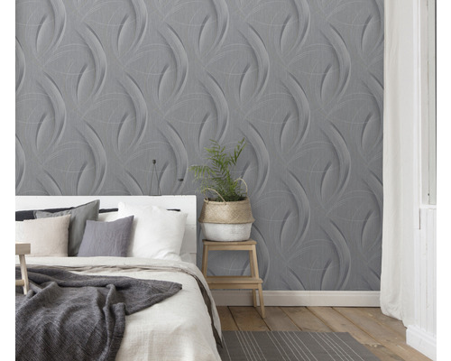 Spálňa so sivou trojrozmernou tapetou a bielou posteľou