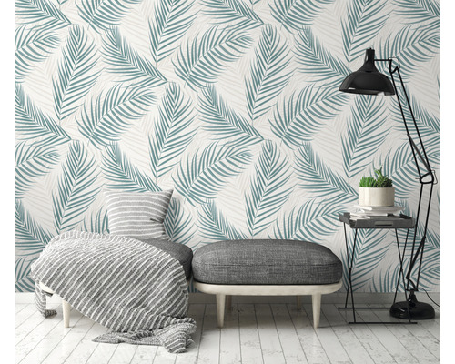 Obývacia izba s tapetou s palmovými listami, stolčekom, lampou a príručným stolíkom pre svetlé prostredie