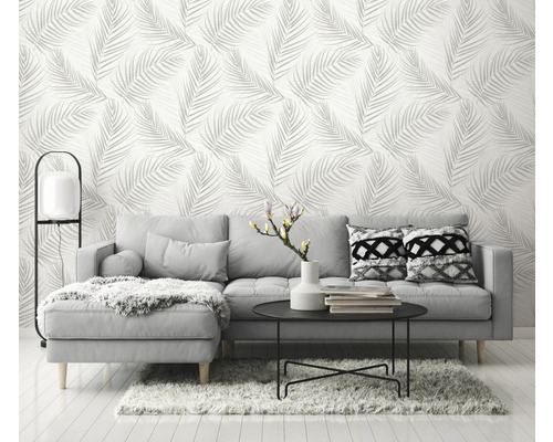 Obývacia izba so sivou pohovkou a tapetou s listovým vzorom