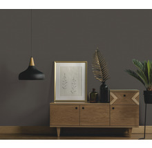 Obývacia izba s komodou, rámom na obrazy, izbovou rastlinou a závesným svietidlom