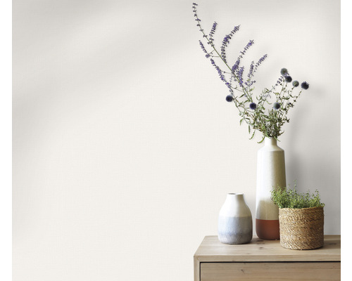 Dekoratívne vázy s kvetinami na drevenom stole pred stenou