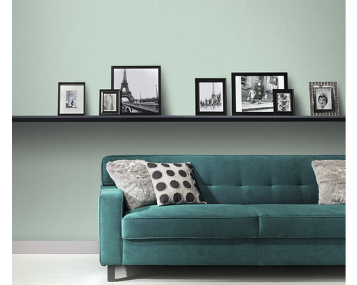 Obývacia izba s policou, obrázkami a zelenou pohovkou