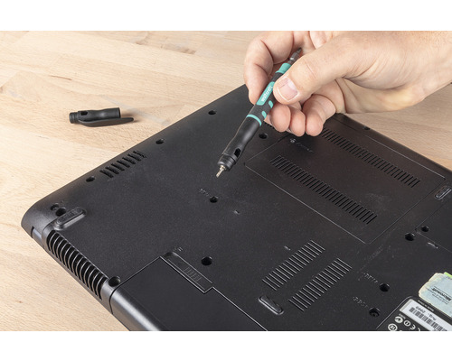 Muž opravuje notebook skrutkovačom