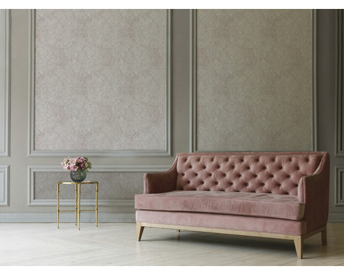 Obývacia izba s nástennými panelmi, vzorovanou tapetou, prešívanou pohovkou a príručným stolíkom s kvetinami