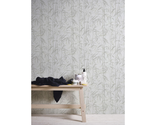 Tapeta s bambusovým vzorom za dreveným stolom s produktmi starostlivosti a handričkou