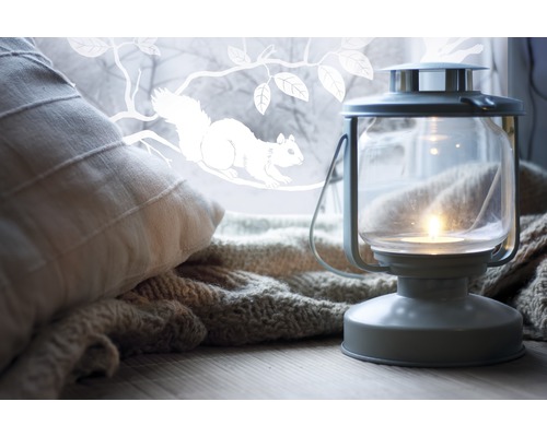 Dekoratívna scéna s vankúšom, pletenou dekou a lampášom so sviečkou