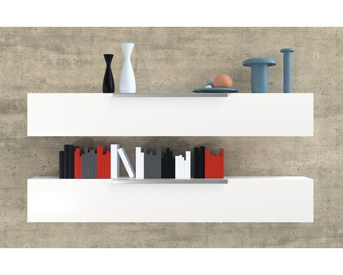 Dve biele nástenné police s dekoratívnymi predmetmi a knihami na betónovej stene