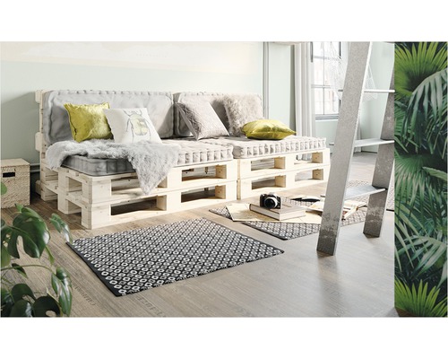 Obývacia izba s pohovkou z paliet, vankúšmi a kobercom na drevenej podlahe