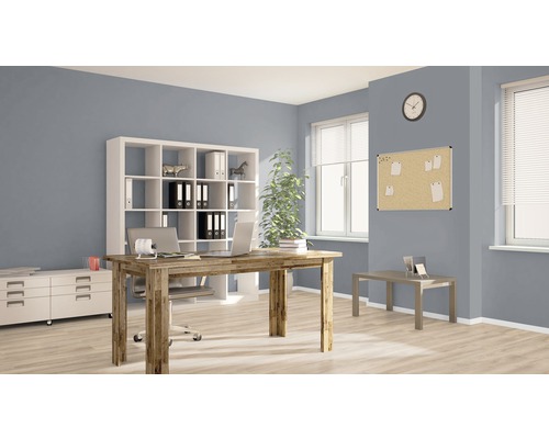 Kancelária so stolom, regálom a nástenkou v svetlej miestnosti.