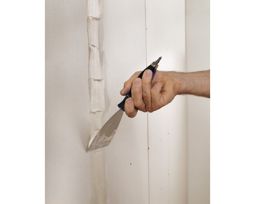 Ruka špachtľou škáry na sadrokartónovej stene pomocou špachtle