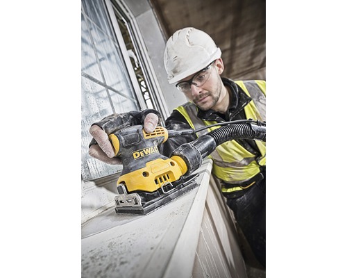 Remeselník brúsi okenný rám pomocou vibračnej brúsky DeWalt