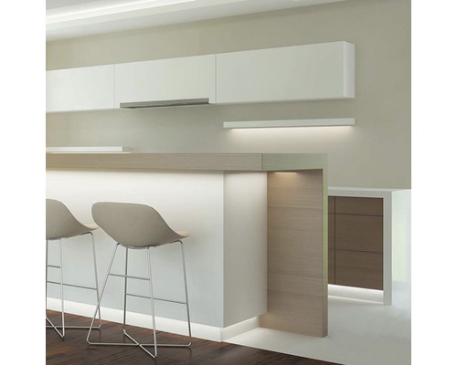 Moderná kuchyňa s bielymi hornými skrinkami, barovým pultom s barovými stoličkami a atmosférickým osvetlením