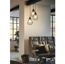 Závesná lampa s tromi svietidlami nad pohovkou v obývacej izbe.
