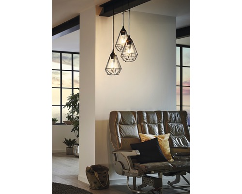 Závesná lampa s tromi svietidlami nad pohovkou v obývacej izbe.