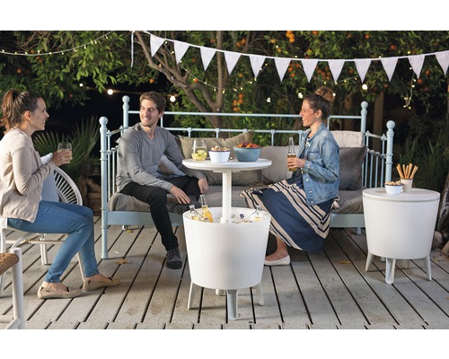 Traja ľudia sedia na terase s chladiacimi boxmi a odkladacími stolíkmi