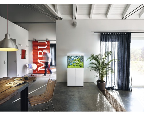 Obývacia izba s akváriom na skrinke, jedálenským stolom a závesmi