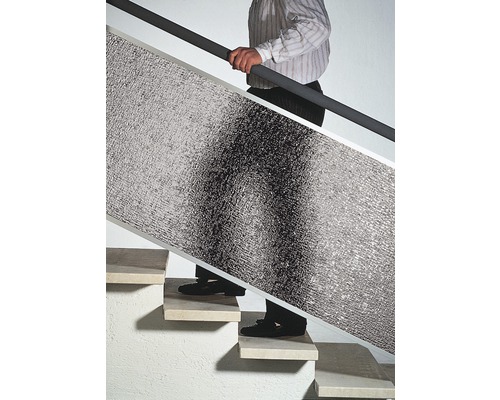 Muž nesie izolačnú dosku po schodoch