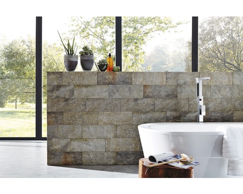 Moderná kúpeľňa s obkladom z prírodného kameňa, voľne stojacou vaňou a izbovými rastlinami