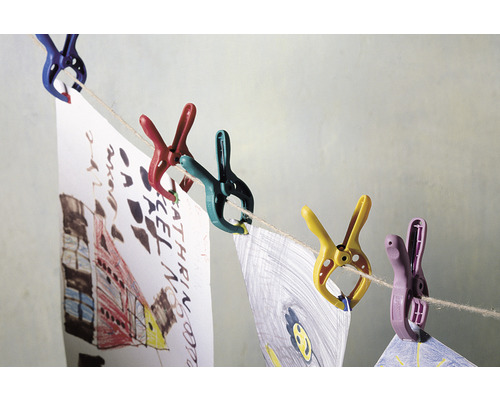 Farebné štipce držia detské kresby na šnúre na prádlo