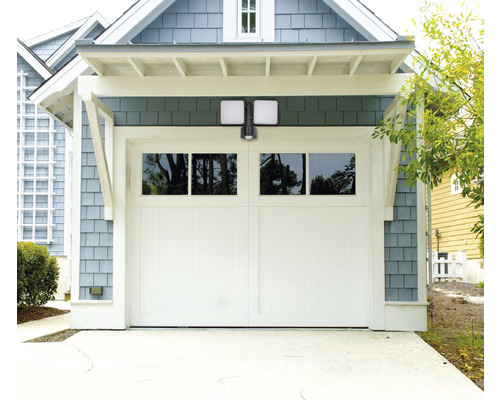 Garáž s bielymi garážovými dverami a vonkajším LED svetlom