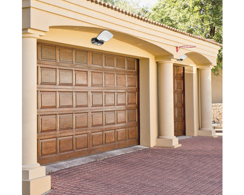 Garáž s dvomi drevenými bránami a dvomi vonkajšími svetlami.