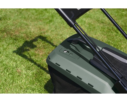 Detailný pohľad na kosačku na trávu so zberným košom na trávniku