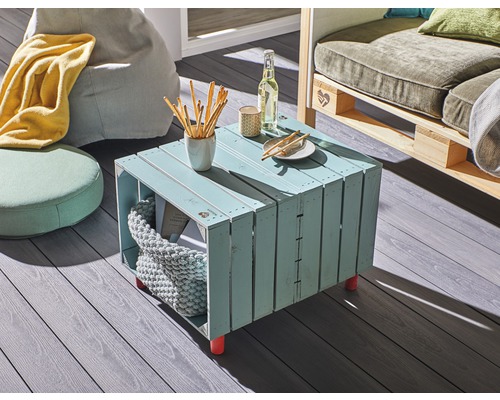 Obývacia izba so stolom z drevených debien, sedacími vakmi a pohovkou z paliet